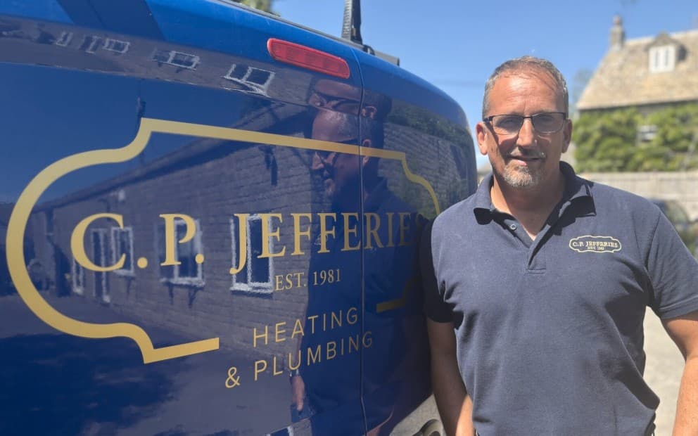 Jason Rogan standing next to a van that says 'C.P. Jefferies' on the back.