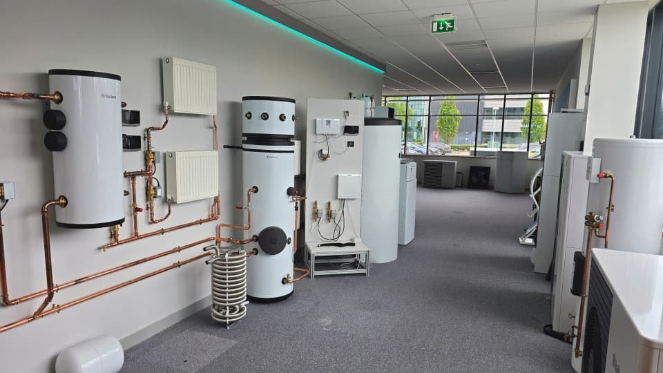 A room filled with multiple water heaters and interconnected pipes, showcasing a full Vaillant heating system.