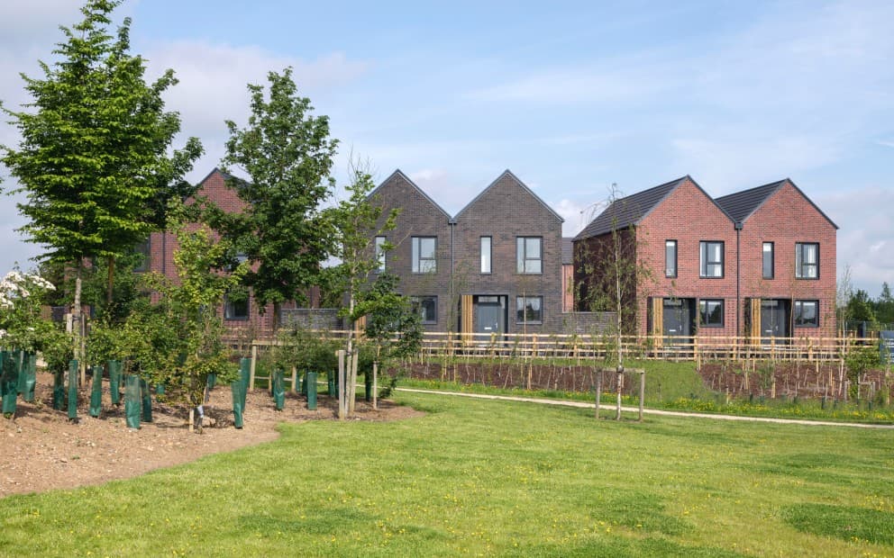 Aerial view of a new housing development, highlighting its modern design and surrounding green areas