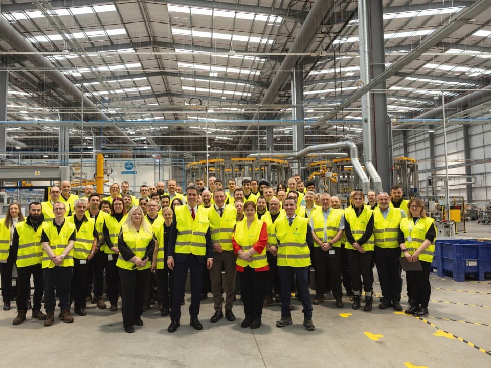 Large group of people wearing hi-vis jackets in a warehouse