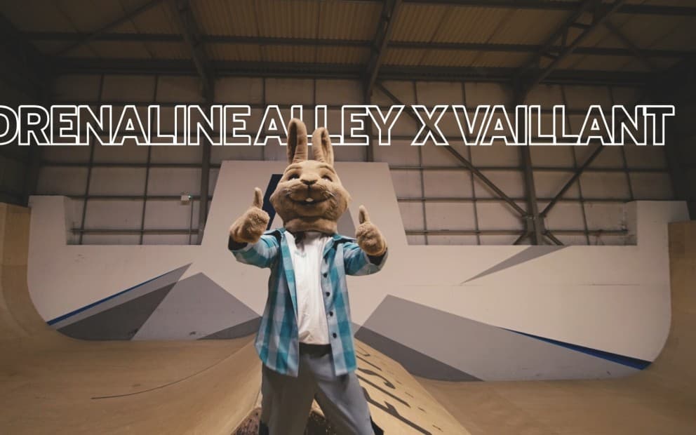 Vaillant mascot at Adrenaline Alley skate park. Text in the background reads Vaillant X Adrenaline Alley