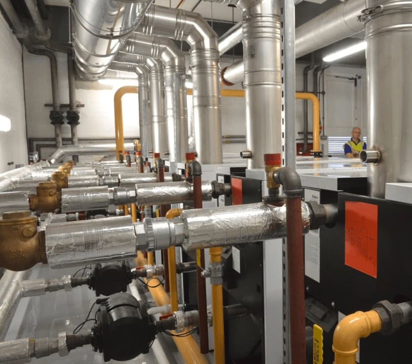 A spacious industrial room filled with various pipes and valves, showcasing a complex network of machinery.