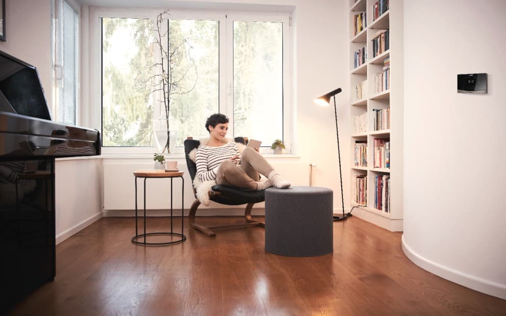 Woman sat on a chair with her feet up looking at a tablet.