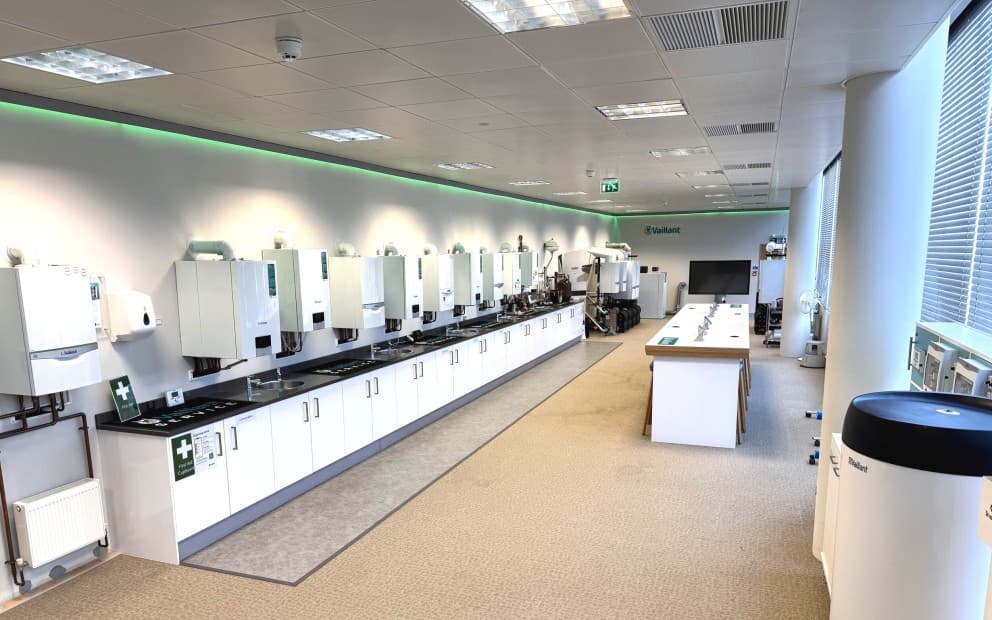 Training room with Vaillant boilers on a wall with cupboards on the ground.