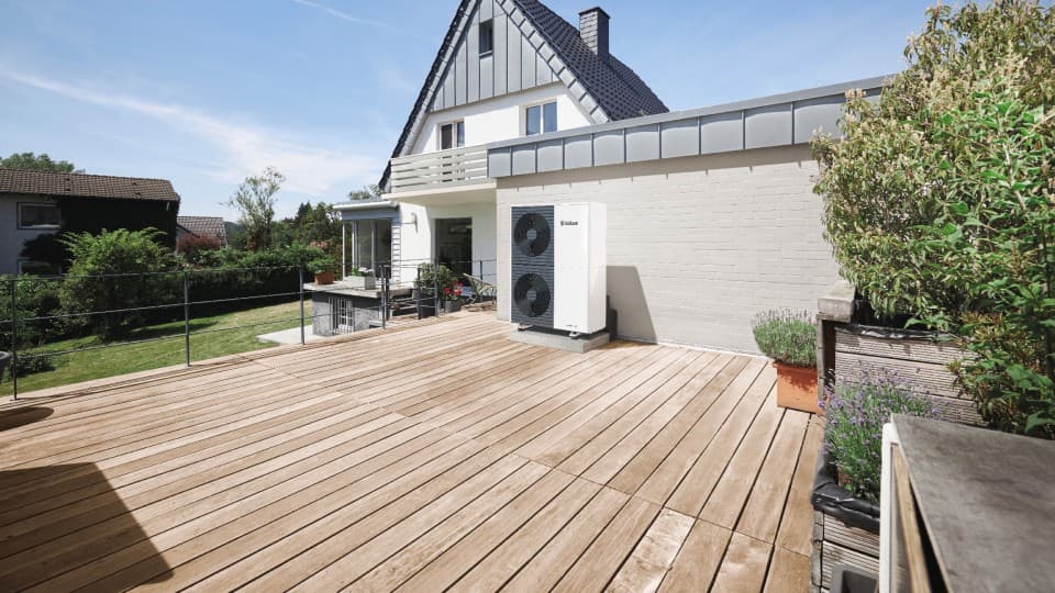 Double stacked aroTHERM plus heat pump unit on a patio decking. Surrounding by plants and garden furniture.