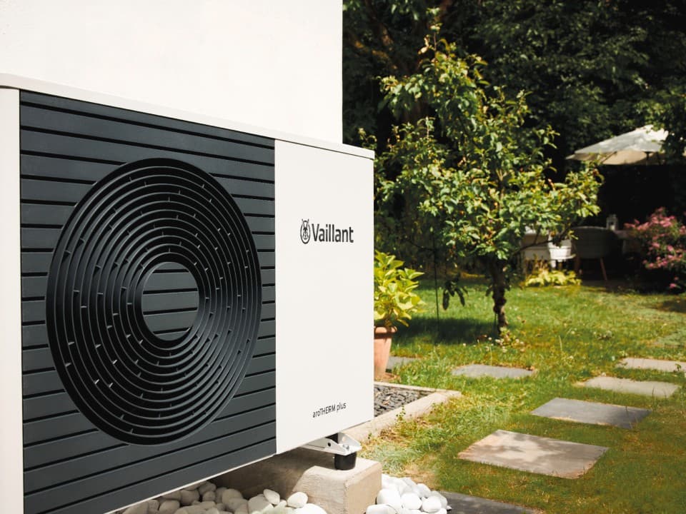 Side view of a Vaillant heat pump in a garden.