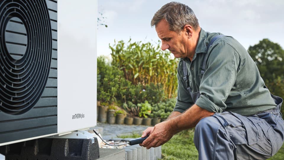 installer doing work on a heat pump
