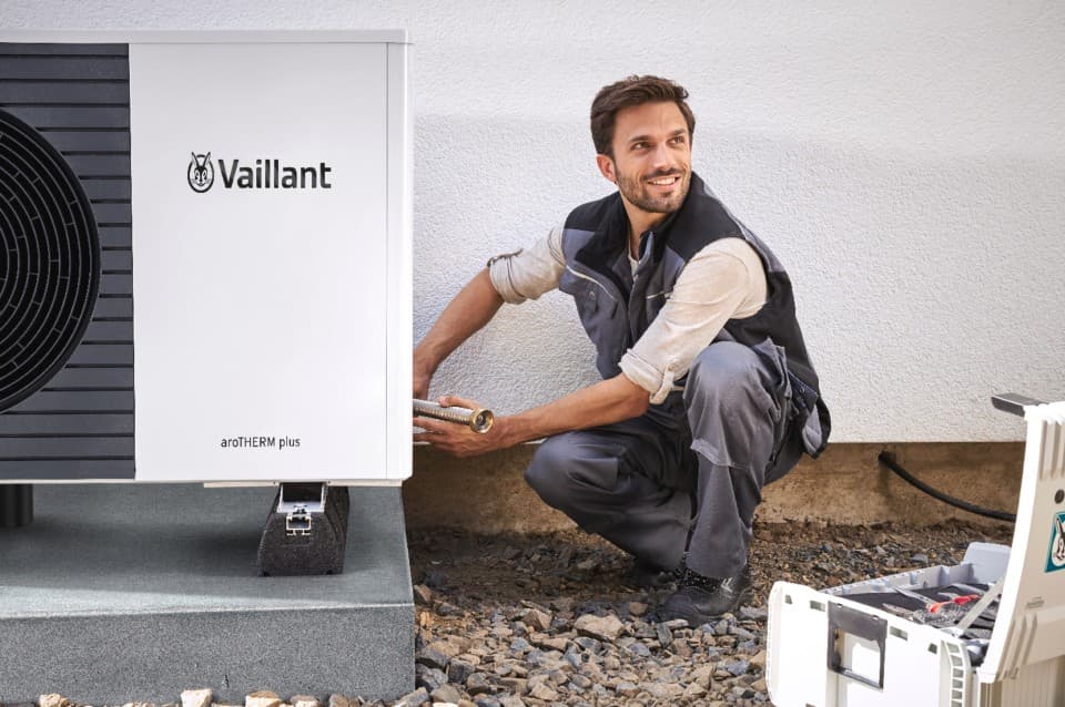 Two men carrying our a heat pump installation