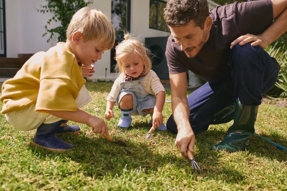 A man and two children doing some gardening.