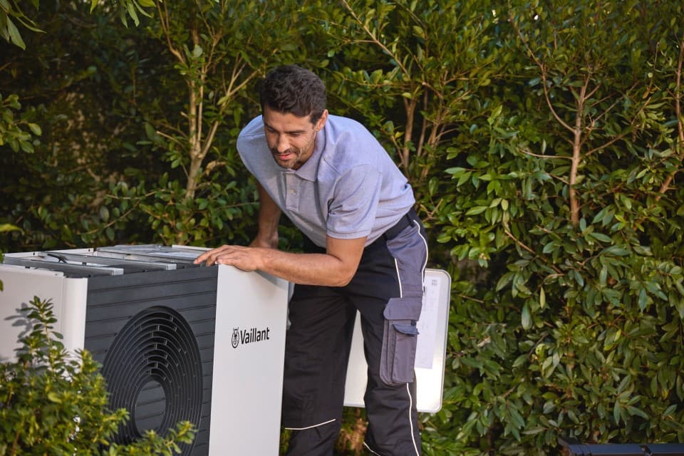 Woman walking with a brief case with a double stacked heat pump next to her.