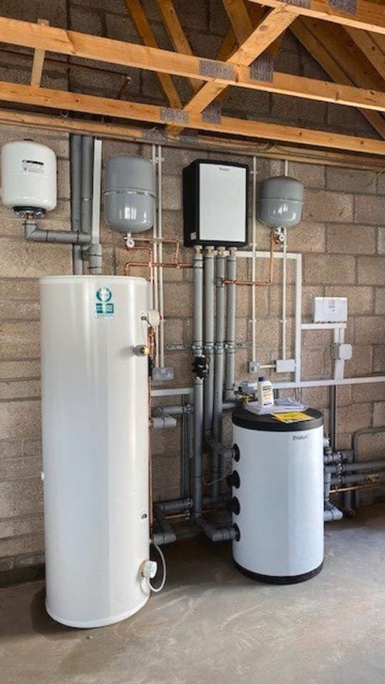 Boiler room with a cylinder and other pipe work and plastic tubes.