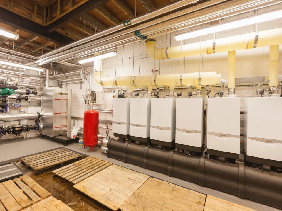 A row of boilers and other components in a room