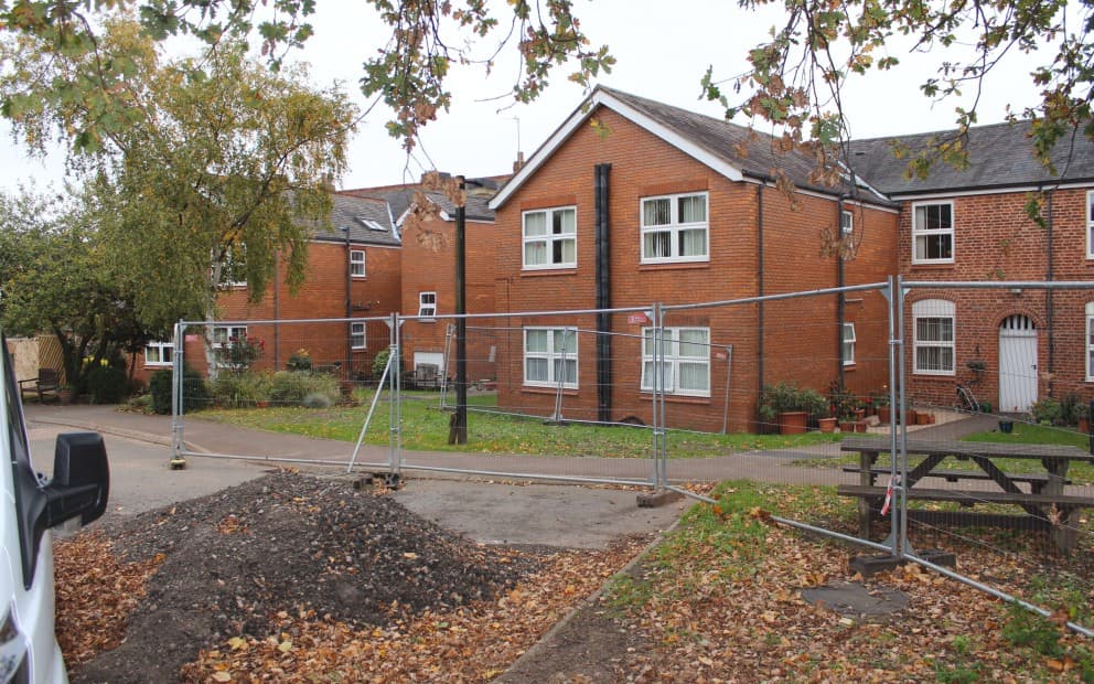 Large brick house with a metal fence around it