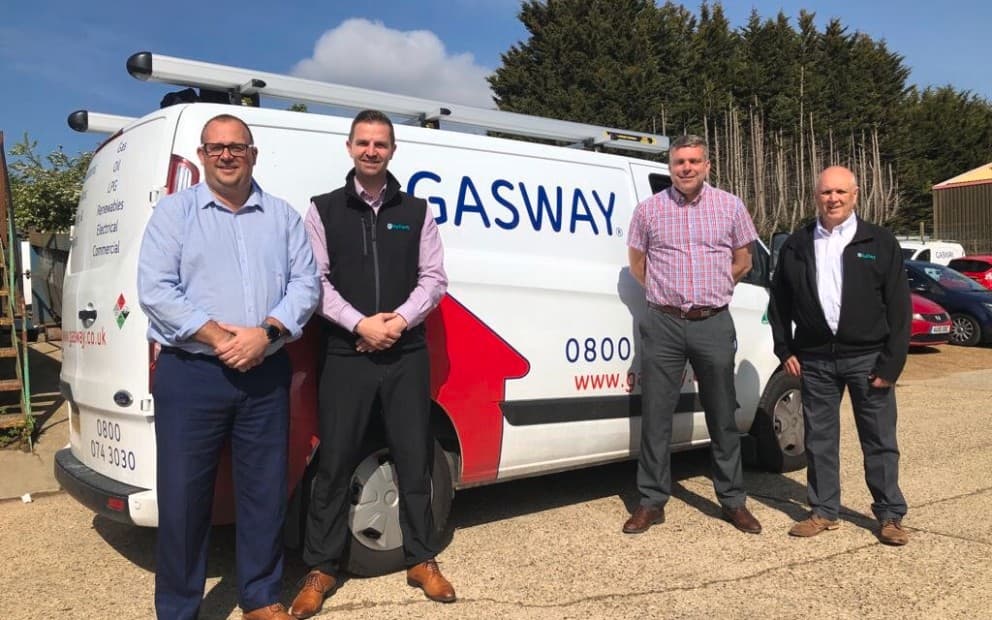 Four people stood in front of a white van.