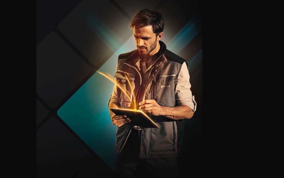 Man looking down at a tablet with an orange glow coming from the screen.