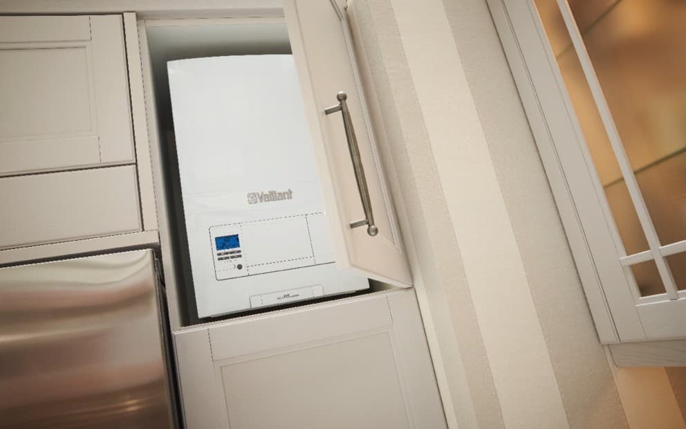 A Vaillant boiler in a cupboard with the cupboard door ajar.