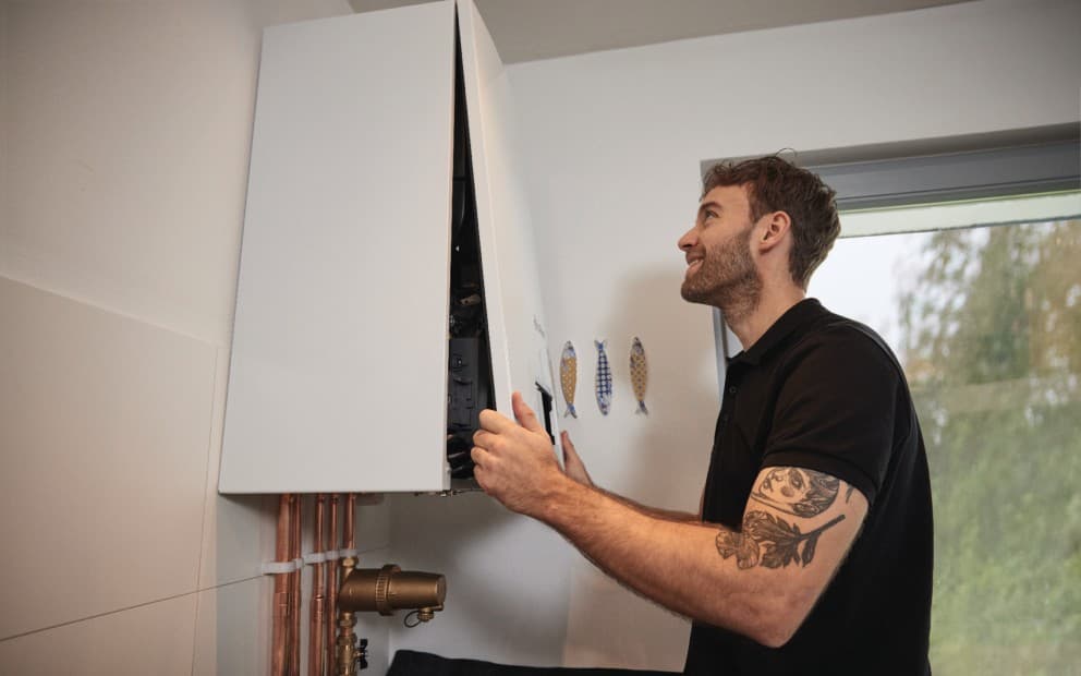 Man putting the front panel of the boiler on.