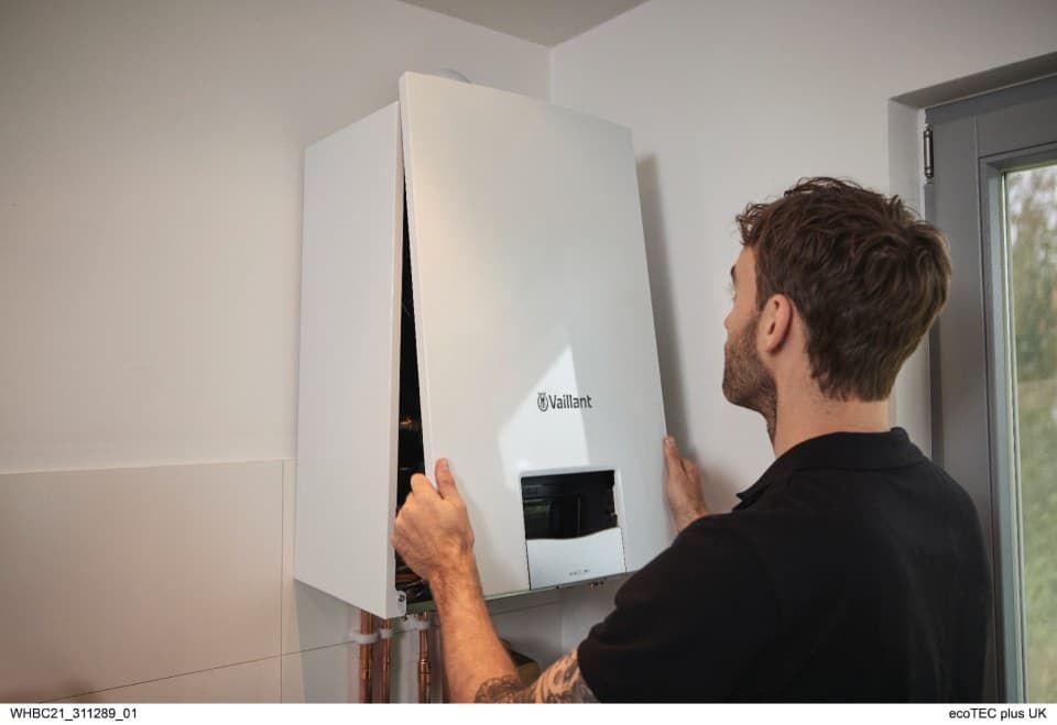 Installer putting the front casing of a boiler