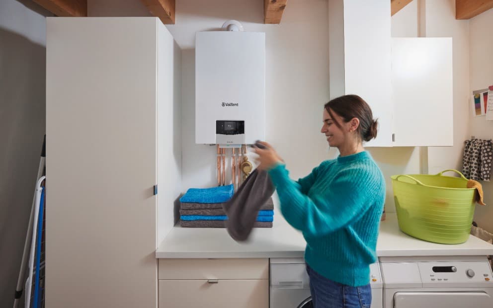 Woman folding towels in a utility room with a ecoTEC plus boiler in the background